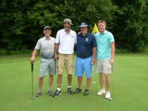 Four old men in golf clothes posing for a photo